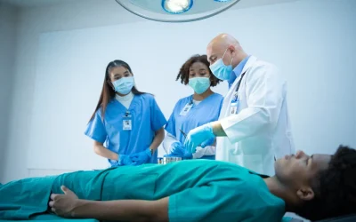 Medical professionals in scrubs assisting a patient in a hospital bed